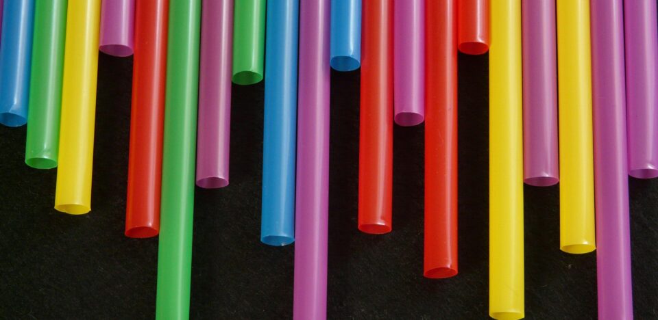 Multicolored plastic straws arranged in a vibrant, artistic pattern.