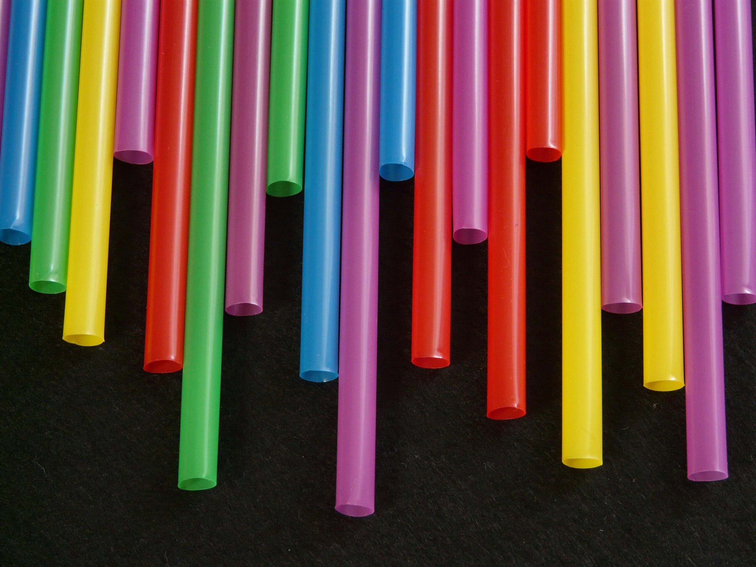 Multicolored plastic straws arranged in a vibrant, artistic pattern.